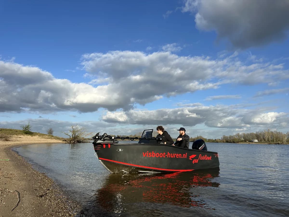 FishHawk 450 aangemeerd bij een dijk, twee inzittenden aan boord