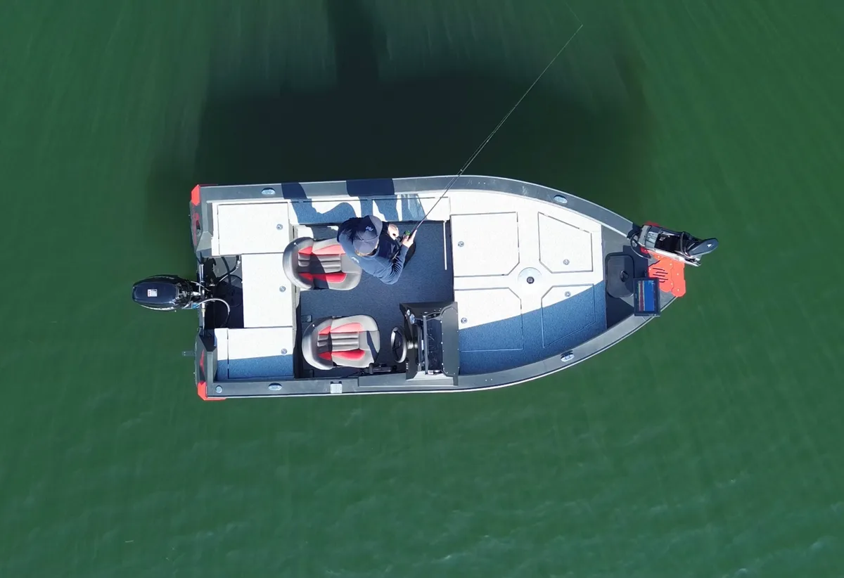 Dronefoto recht van boven op een visser aan boord van de FishHawk 450