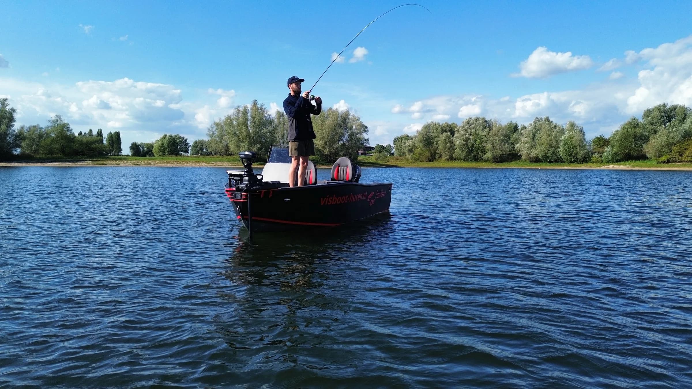 Visser met doorgebogen hengel aan boord van de vaarbewijsvrije FishHawk 450